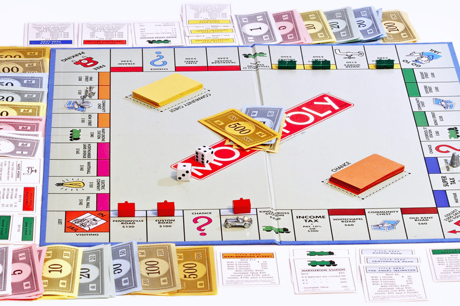 Bàn cờ Monopoly với tiền giấy và các quân cờ bày trí trên mặt bàn trắng