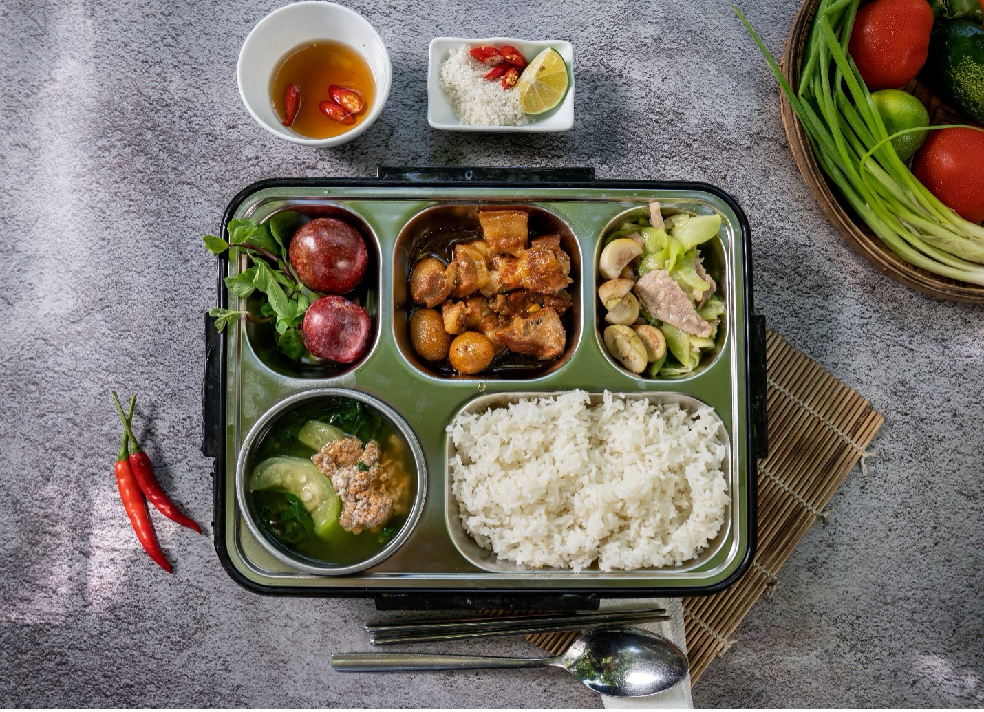 Khay cơm gia đình với nhiều món ăn như thịt kho cà tím canh rau và rau sống