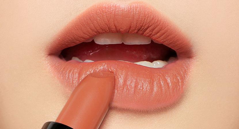Son môi màu cam đất được tô lên môi người phụ nữ