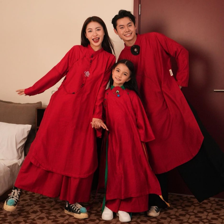 Gia đình ba người mặc áo dài đỏ tươi tắn đón xuân mới