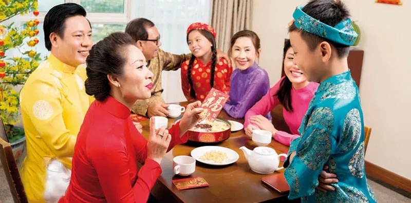 Gia đình quây quần mừng tuổi đầu năm mới với phong bao lì xì và trà nóng